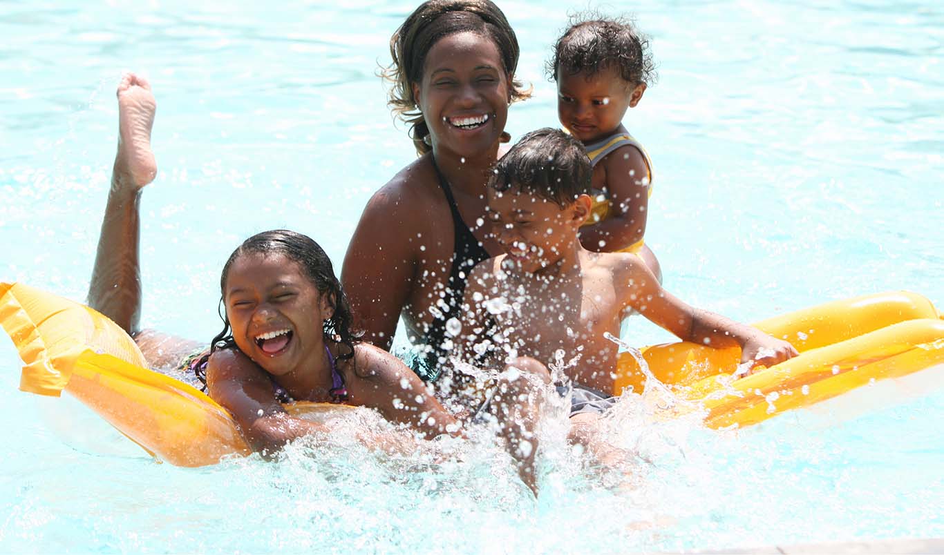 Young family playing together in a clean swimming pool